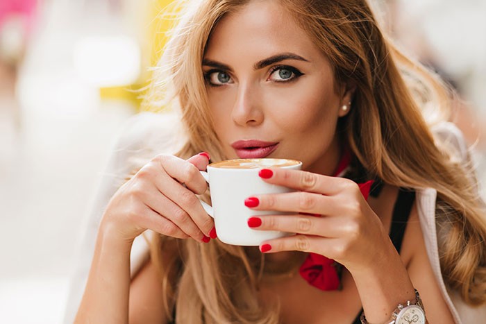 Mlađa žena uživa u šoljici kafe